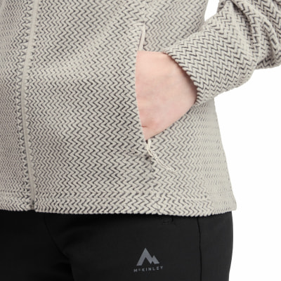 Detail einer Damen-Fleecejacke mit Reißverschlusstasche und Fischgrätenmuster. Detail einer Damen-Fleecejacke mit Reißverschlusstasche und Fischgrätenmuster.