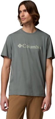 Ein Mann in einem grauen T-Shirt mit Columbia-Logo und brauner Hose.