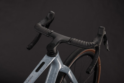 Detail eines modernen Gravelbikes mit schwarzem Lenker und grauem Rahmen. Detail eines modernen Gravelbikes mit schwarzem Lenker und grauem Rahmen.