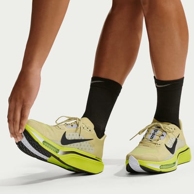 Egy futó sárga Nike futócipőben és fekete zokniban nyújtja a lábát.