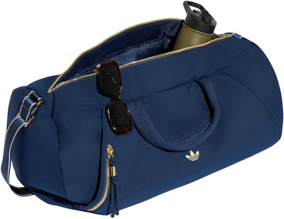 Dunkelblaue Adidas Sporttasche mit goldenem Reißverschluss und Logo. Dunkelblaue Adidas Sporttasche mit goldenem Reißverschluss und Logo.