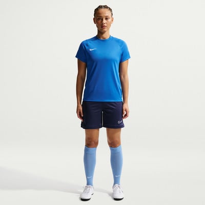 Frau in blauem Shirt, dunkelblauer Hose und hellblauen Socken.