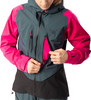 Eine Frau öffnet eine pinke Jacke mit grauen und schwarzen Einsätzen.