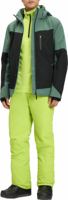 Ein Mann in einer grünen Skijacke und hellgrüner Hose mit schwarzen Schuhen. Ein Mann in einer grünen Skijacke und hellgrüner Hose mit schwarzen Schuhen.