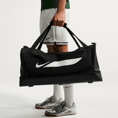 Ein Mann trägt eine schwarze Nike Sporttasche mit großem weißem Logo. Ein Mann trägt eine schwarze Nike Sporttasche mit großem weißem Logo.