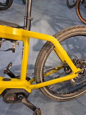 Gelber Rahmen eines E-Bikes mit sichtbarem Bosch-Motor und Hinterrad. Gelber Rahmen eines E-Bikes mit sichtbarem Bosch-Motor und Hinterrad.