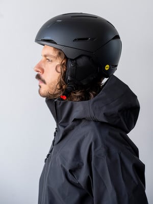 Mann in schwarzem Skihelm und Jacke, Seitenansicht
