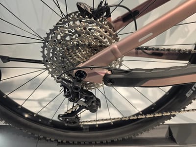 Detail des hinteren Schaltwerks und der Kassette an einem rosafarbenen Fahrrad. Detail des hinteren Schaltwerks und der Kassette an einem rosafarbenen Fahrrad.