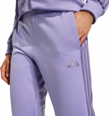 Lila Trainingshose mit Adidas-Logo und drei Streifen an der Seite. Lila Trainingshose mit Adidas-Logo und drei Streifen an der Seite.