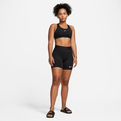 Eine Frau in einem schwarzen Sportoberteil und Shorts mit Nike-Logo. Eine Frau in einem schwarzen Sportoberteil und Shorts mit Nike-Logo.