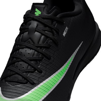 Schwarzer Nike Fußballschuh mit markantem grünen Logo und Streifen. Schwarzer Nike Fußballschuh mit markantem grünen Logo und Streifen.