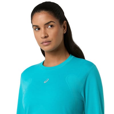 Nő türkizzöld, hosszú ujjú pólóban, Asics logóval. Nő türkizzöld, hosszú ujjú pólóban, Asics logóval.