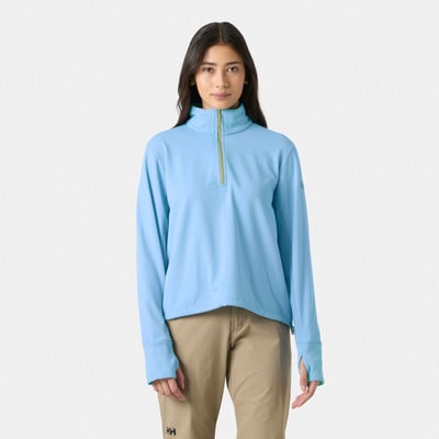 Frau in einem blauen Pullover mit Stehkragen und kurzem Reißverschluss und einer beigen Hose. Frau in einem blauen Pullover mit Stehkragen und kurzem Reißverschluss und einer beigen Hose.