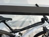 Teil eines weißen Mountainbikes mit schwarzem Rahmen und Sattel auf einem Ständer.