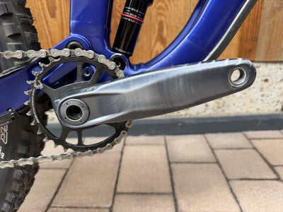 Nahaufnahme der Kurbel und Kette eines Mountainbikes mit Dämpfer im Hintergrund. Nahaufnahme der Kurbel und Kette eines Mountainbikes mit Dämpfer im Hintergrund.