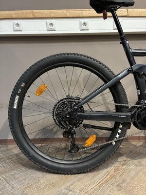 Das Hinterrad eines E-Mountainbikes mit Schaltwerk und orangem Reflektor. Das Hinterrad eines E-Mountainbikes mit Schaltwerk und orangem Reflektor.