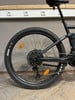 Das Hinterrad eines E-Mountainbikes mit Schaltwerk und orangem Reflektor.