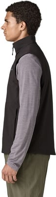 Ein Mann in einer schwarzen Weste und einem grauen Langarmshirt und grüner Hose. Ein Mann in einer schwarzen Weste und einem grauen Langarmshirt und grüner Hose.