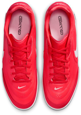 Červené topánky Nike Tiempo Gato s bielym logom a šnúrkami. Červené topánky Nike Tiempo Gato s bielym logom a šnúrkami.