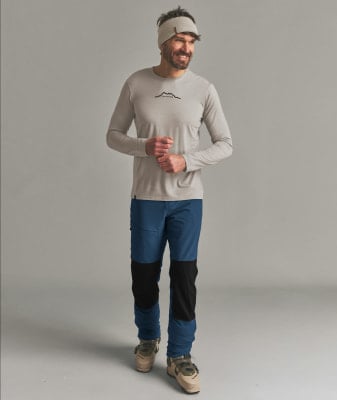 Ein Mann mit Mütze, Langarmshirt und blauer Hose.