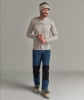 Ein Mann mit Mütze, Langarmshirt und blauer Hose.