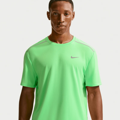Ein Mann in einem grünen Nike-T-Shirt mit reflektierenden Details an den Schultern.