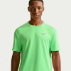 Ein Mann in einem grünen Nike-T-Shirt mit reflektierenden Details an den Schultern.
