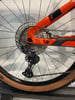 Detail des Schaltwerks eines Mountainbikes mit orangefarbenem Rahmen und breiter Kassette.