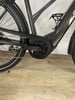 Detail des E-Bike-Rahmens mit Kette und Kurbeln auf Holzboden.