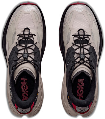 Draufsicht auf ein Paar beige Hoka-Laufschuhe mit schwarzen Schnürsenkeln. Draufsicht auf ein Paar beige Hoka-Laufschuhe mit schwarzen Schnürsenkeln.