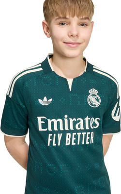 Junge in dunkelgrünem Trikot mit Adidas und Real Madrid Logo. Junge in dunkelgrünem Trikot mit Adidas und Real Madrid Logo.