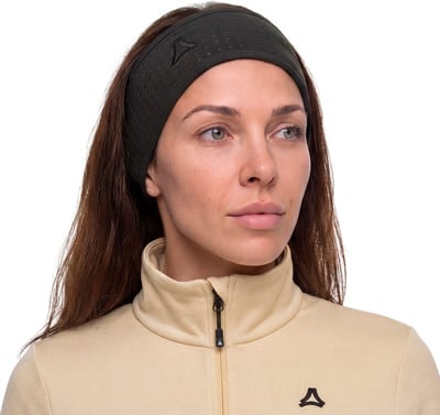 Eine Frau mit einem dunkelgrünen Stirnband und einer beige Jacke mit Reißverschluss. Eine Frau mit einem dunkelgrünen Stirnband und einer beige Jacke mit Reißverschluss.