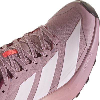 Detail eines Adidas Laufschuhs mit rosa Schnürsenkeln und weißen Streifen.