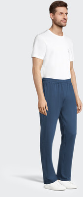 Ein Mann in einem weißen T-Shirt und einer dunkelblauen Hose steht. Ein Mann in einem weißen T-Shirt und einer dunkelblauen Hose steht.
