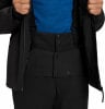 Detail einer Winterjacke mit blauem Hemd und schwarzer Hose.