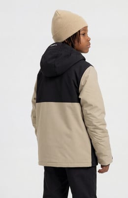 Ein Junge in einer beigen Mütze und einer zweifarbigen Kapuzenjacke posiert für ein Foto. Ein Junge in einer beigen Mütze und einer zweifarbigen Kapuzenjacke posiert für ein Foto.