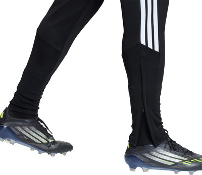 Schwarze Fußballhose mit weißen Streifen und Reißverschlüssen an den Knöcheln.