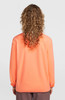 Rückansicht einer Person mit lockigem Haar in einer orangefarbenen Jacke.
