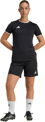 Eine Frau in einem schwarzen Fußballtrikot und Shorts mit weißen Socken und Fußballschuhen. Eine Frau in einem schwarzen Fußballtrikot und Shorts mit weißen Socken und Fußballschuhen.