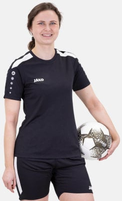 Eine Frau im schwarzen Fußballtrikot und Shorts hält einen Fußball. Eine Frau im schwarzen Fußballtrikot und Shorts hält einen Fußball.
