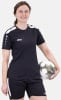Eine Frau im schwarzen Fußballtrikot und Shorts hält einen Fußball.