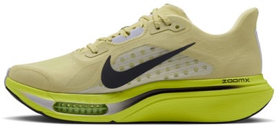 Sárga Nike futócipő fekete swoosh logóval és zöld talppal.