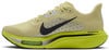 Sárga Nike futócipő fekete swoosh logóval és zöld talppal.
