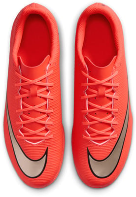 Pohľad zhora na oranžové futbalové kopačky Nike so šnúrkami a logom. Pohľad zhora na oranžové futbalové kopačky Nike so šnúrkami a logom.