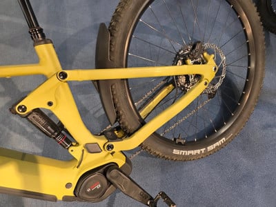 Gelber E-Bike-Rahmen mit Dämpfer und Hinterrad mit Smart Sam Reifen. Gelber E-Bike-Rahmen mit Dämpfer und Hinterrad mit Smart Sam Reifen.