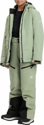 Junge in grüner Winterjacke und Hose mit schwarzen Details.