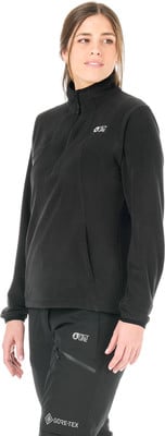 Model in schwarzem Fleece-Pullover mit Stehkragen und schwarzer Hose mit Gore-Tex-Logo.
