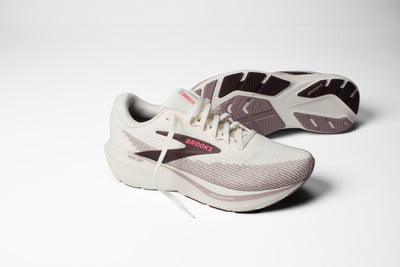 Weiße Brooks Laufschuhe mit rosa und dunkelbraunen Details auf weißem Hintergrund. Weiße Brooks Laufschuhe mit rosa und dunkelbraunen Details auf weißem Hintergrund.