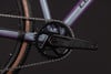 Detail des Kettenblatts und der Kette an einem lila Fahrrad mit ACID-Logo.