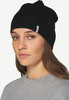 Eine Frau trägt eine schwarze Mütze und einen grauen Pullover.